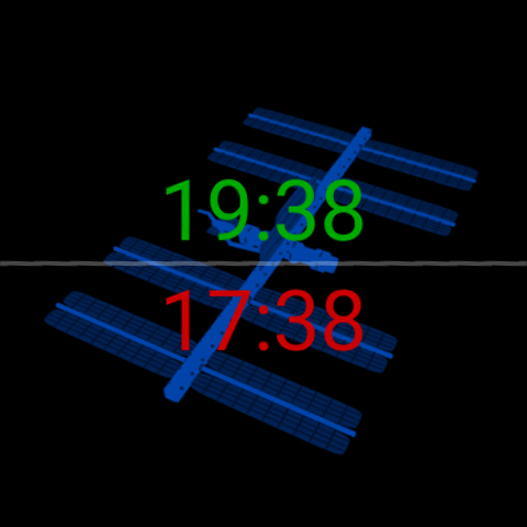 Zulu Face con una silhouette blu della Stazione spaziale internazionale dietro gli orari: ora locale 19:38 in verde in alto, ora Zulu/UTC 17:38 in rosso in basso, su nero.